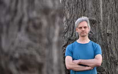 Christian Bläul steht vor einem Baum, die Arme verschränkt. Quelle: Matthias Rietschel